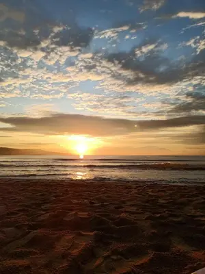 a sunset on a beach with the ocean at Trakia Plaza Apartament Sunny Beach in Sunny Beach