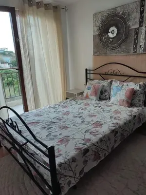 a bedroom with a bed with a floral comforter at Созополски Рай in Sozopol