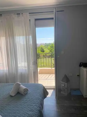 a bedroom with a bed and a sliding glass door at Nessebar panoramic apartment in Nesebar