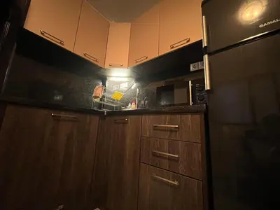 a kitchen with wooden cabinets and a refrigerator at Vqra Sarafovo in Burgas City