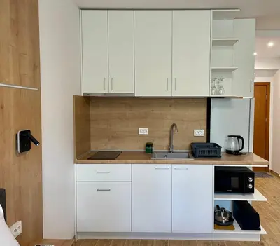 a kitchen with white cabinets and a sink at Royal Marina Beach in Chernomorets