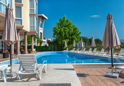 a swimming pool with lounge chairs and umbrellas at Royal Marina Beach in Chernomorets