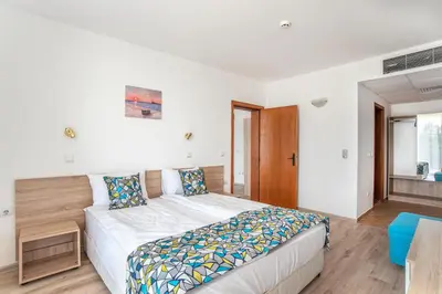 a bedroom with a large bed with a wooden headboard at Royal Marina Beach in Chernomorets