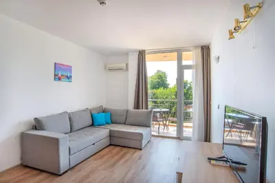 a living room with a couch and a balcony at Royal Marina Beach in Chernomorets