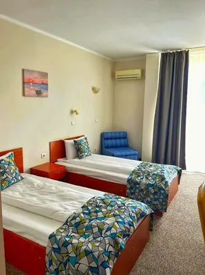 a hotel room with two beds and a chair at Royal Marina Beach in Chernomorets