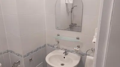 a white bathroom with a sink and a mirror at Royal Marina Beach in Chernomorets