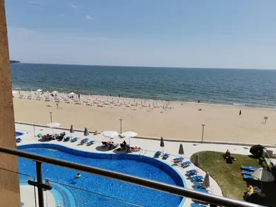 a view of a beach with a swimming pool and the ocean at Апартамент Б306 в Обзор Бийч Резорт на първа линия с перфектен изглед към плажа! in Obzor