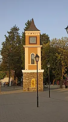 a clock tower in the middle of a street at Чудесно място с басейн 