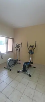a gym with three exercise bikes in a room at Чудесно място с басейн 