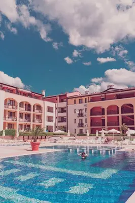 a large swimming pool in front of a hotel at Чудесно място с басейн 