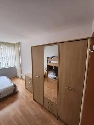 a bedroom with a bed and a dresser with a mirror at Modern 1 Bed Apt, Nesebar Fort in Sunny Beach