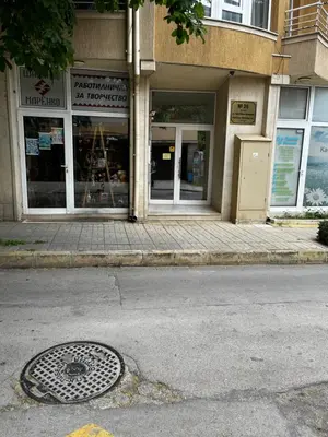 a store front with a manhole in front of a street at Green Central Apartment in Varna City