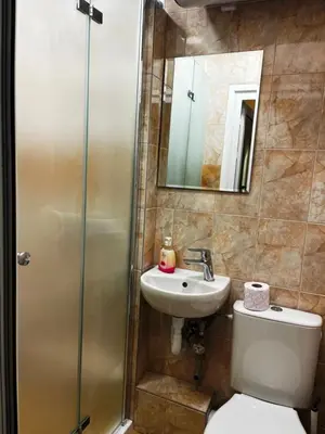 a bathroom with a toilet and a sink and a shower at Green Central Apartment in Varna City