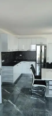 a black and white kitchen with a black chair at Diamond Beach Luxus Apart Obzor 28 in Obzor